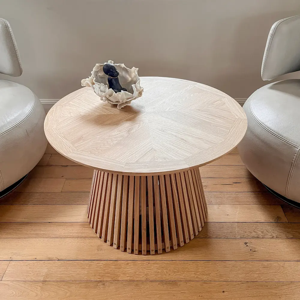 Table basse ronde en chêne massif avec plateau en chevron et pied central.